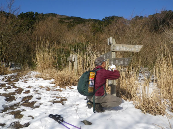 雪が残る小爪峠で作業をするM