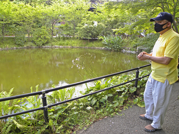 フナやアメンボが自生する池のほとりに立つ岩野園長