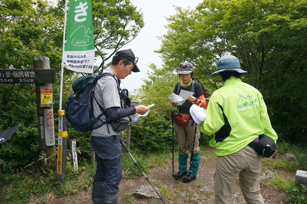 記念品とアンケート用紙を受け取る登山者夫婦