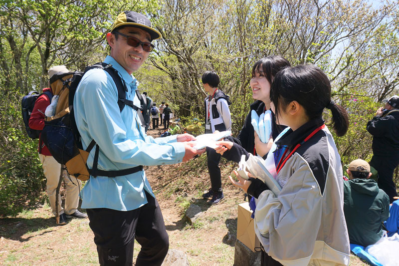 ワンダーフォーゲル部女子部員からアンケートをお願いされる登山者