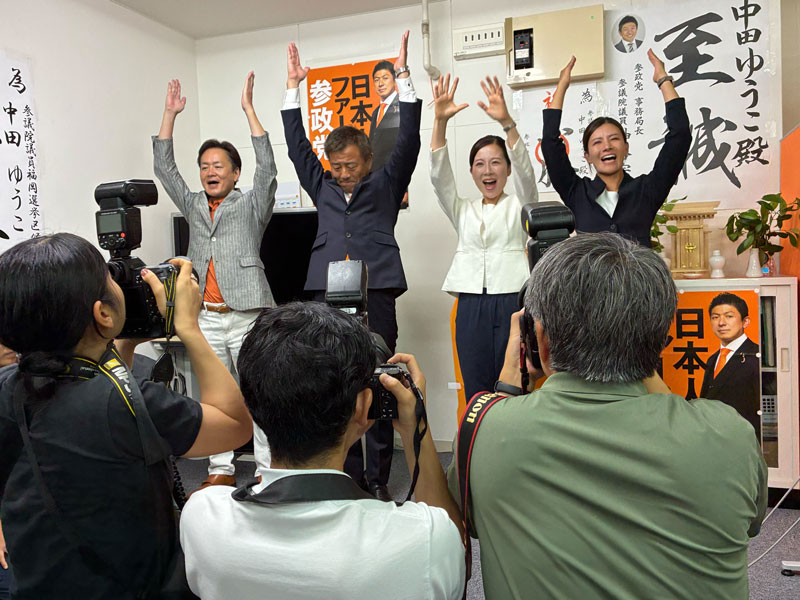 当選確実の報を受けて万歳する参政党の中田優子氏と支持者ら