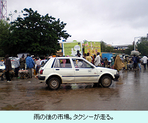 雨の後の市場。タクシーが走る。