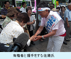 有権者と握手をする佐藤氏