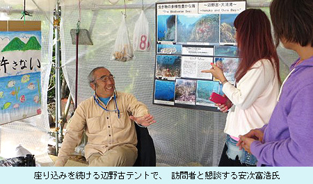 座り込みを続ける辺野古テントで、 訪問者と懇談する安次富浩氏