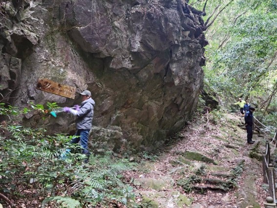 渓谷奥地の岩に電気ドリルで取り付けた表示板を磨く 「ダゴ岩」　足元にブリキの表示板が残っていた
