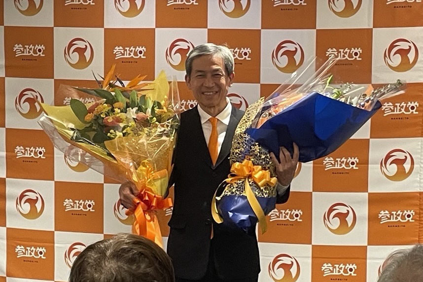 比例区での当選確実の報を受けて支援者から花束を受け取る木下敏之氏